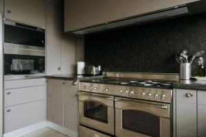 a kitchen with a stainless steel stove and appliances at Magnificent loft - 3 bedroom duplex in Brussels