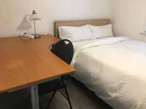 a desk with a bed next to a desk with a bedskirts at Comfy 3-Bedroom Home with Modern Upgrades in London +9 photos