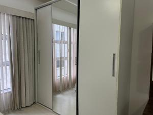 a large mirror in a room with windows at Condomínio Serra loft in Teresópolis