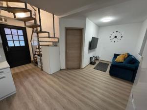 a living room with a blue couch and a spiral staircase at Hiška HOME- TERME ČATEŽ - VKLJUČENE KOPALNE KARTE in Čatež ob Savi