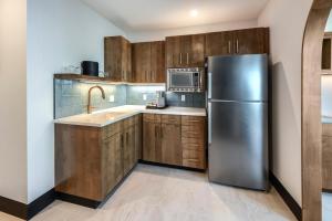 a kitchen with wooden cabinets and a stainless steel refrigerator at Allred Hotel in Newport +37 photos