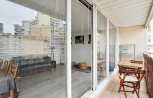 Zimmer mit Glastüren, einem Tisch und Stühlen in der Unterkunft Le cocon in Nanterre