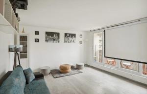 ein Wohnzimmer mit einem Sofa und einem Großbild-TV in der Unterkunft Le cocon in Nanterre