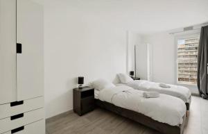 zwei Betten in einem Schlafzimmer mit weißen Wänden in der Unterkunft Le cocon in Nanterre