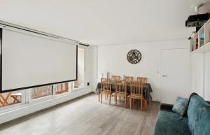 ein Wohnzimmer mit einem Tisch und einem großen Bildschirm in der Unterkunft Le cocon in Nanterre