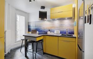 eine Küche mit gelben Schränken und einem Waschbecken in der Unterkunft Le cocon in Nanterre + 2 Fotos