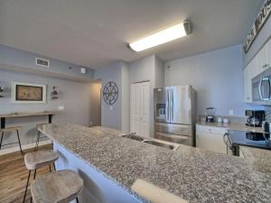 a kitchen with a counter top and a refrigerator at Shores of Panama 1307, Two Masters! Under 25 ok! in Panama City Beach