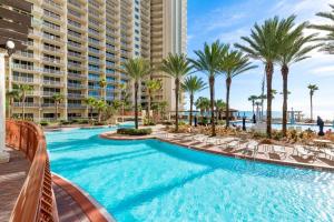 een zwembad met palmbomen en een resort bij Shores of Panama 2115, 2BR 2 BA, sleeps 6 in Panama City Beach