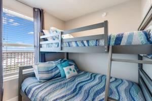 een slaapkamer met stapelbedden in een kamer met een raam bij Shores of Panama 2115, 2BR 2 BA, sleeps 6 in Panama City Beach +27 foto's