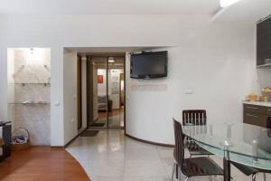 a living room with a table and a tv on a wall at Opera House Apartments in Vilnius