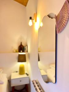 a room with a mirror and a bed and a lamp at Villa Seara - Casas da Vinha in Celorico de Basto