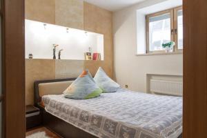 ein Schlafzimmer mit einem Bett mit Kissen und einem Fenster in der Unterkunft Opera House Apartments in Vilnius