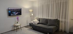 a living room with a couch and a tv at Barona apartement in Jelgava