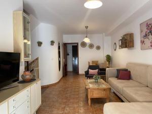 Una sala de estar con un sofá y un televisor. en La Bondadosa, en El Bosque