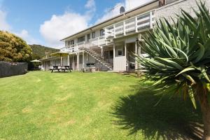 a building with a large yard in front of it at Aarangi Tui Motel in Paihia