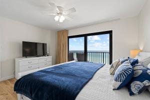 a bedroom with a bed with a television and a window at Commodore 606 3 BR 3 BA Sleeps 12 in Panama City Beach +85 photos