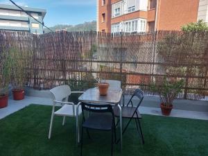 a table and chairs on a patio with grass at 10m Casco Viejo in Bilbao +4 photos