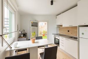 a kitchen with white cabinets and a table with chairs at 10m Casco Viejo in Bilbao