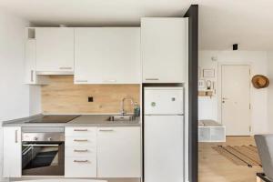 a kitchen with white cabinets and a stainless steel refrigerator at 10m Casco Viejo in Bilbao
