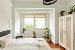 a bedroom with a bed and potted plants at 10m Casco Viejo in Bilbao