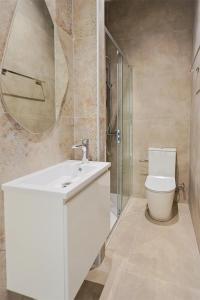a bathroom with a toilet and a sink and a mirror at Lito - Slow Living in Larnaka +18 photos