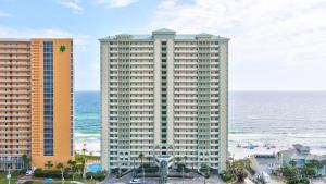 un grande edificio vicino all'oceano con l'oceano dietro di esso di Celadon 109 - 3BR 3BA a Panama City Beach