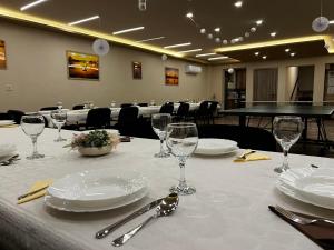 a table with white plates and glasses on a table at Seregély Vendégház in Kunfehértó