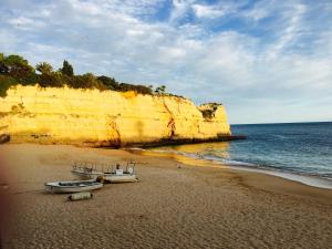twee boten op een zandstrand naast de oceaan bij Villa Vilamar in Porches
