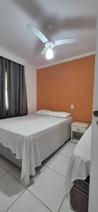 a bedroom with a bed with a ceiling fan at JL Temporadas - Apto Village Taperapuan in Porto Seguro +26 photos