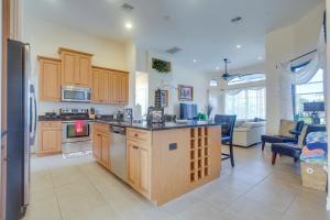 cocina con armarios de madera y sala de estar. en Upscale Marco Island Villa with Outdoor Bar and Pool!, en Marco Island