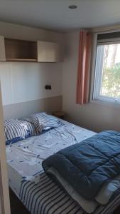 a bedroom with a bed and a window at MH 475 ELEGANZIA 2CH ET 1sdb dans camping 4 étoiles avec parc aquatique in Saint-Julien-en-Born