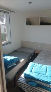 a room with two beds and a window at MH 475 ELEGANZIA 2CH ET 1sdb dans camping 4 étoiles avec parc aquatique in Saint-Julien-en-Born