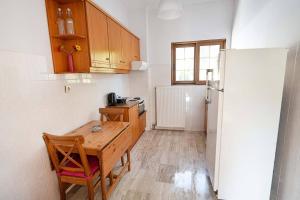 a kitchen with a wooden table and a refrigerator at Kanali seaside apartment Poros 1 in Poros
