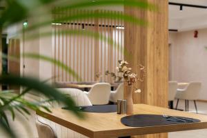 a wooden table with a vase of flowers on it at AMAR Design Hotel by HMG in Sofia