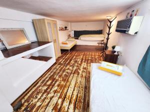 a small room with a wooden floor and a bedroom at La Guardia on the boulevard in Tel Aviv