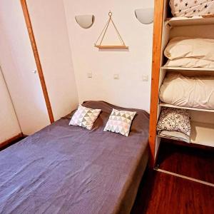 a small bedroom with a bunk bed with two pillows at le petit chambourguet in Besse-et-Saint-Anastaise