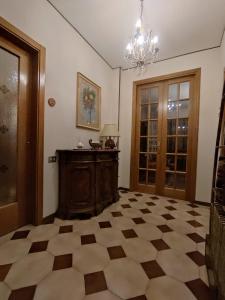 a room with a checkered floor and a chandelier at La Jolie in Pisa +1 photo