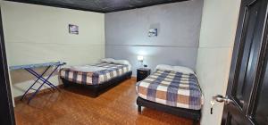 a room with two beds and a table in it at Cabaña en un lugar tranquilo in Tulcán