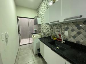 a small kitchen with a sink and a toilet at Casa Aconchego 1 Residencial Santa Terezinha in Dourados