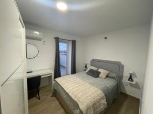 a bedroom with a bed and a desk and a window at El Rincón del Mirador in Carboneras de Guadazaón