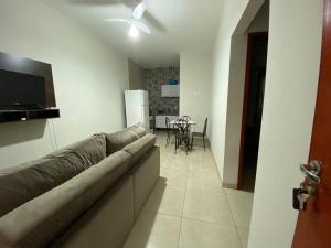 a living room with a couch and a kitchen with a table at Casa Aconchego 2 Residencial Santa Terezinha in Dourados
