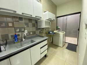 a small kitchen with a sink and a toilet at Casa Aconchego 2 Residencial Santa Terezinha in Dourados +3 photos