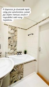a bathroom with a tub and a sink at Apartmán na Žerotínce in Šumperk +10 photos