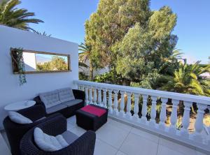 balcón con sofá, sillas y árboles en Apartment Residencia Carabela, en Costa del Silencio