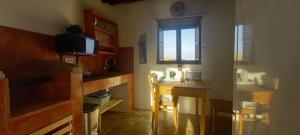 a room with a kitchen with a desk and a window at Sitio Madre María in Zarza