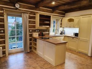 una cucina con mobili bianchi e una grande finestra di Villa in Cerna Hora near Ski Slopes a Horní Maršov