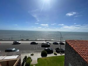 a parking lot with cars parked next to the ocean at Punta Iglesia in Mar del Plata