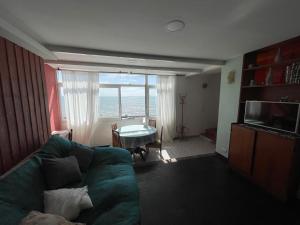 a living room with a green couch and a table at Punta Iglesia in Mar del Plata