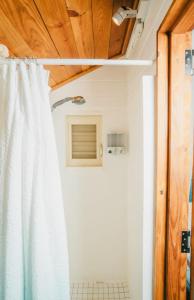 a bathroom with a shower with a white shower curtain at AMAZING Bay View Marea 2-2 in Culebra