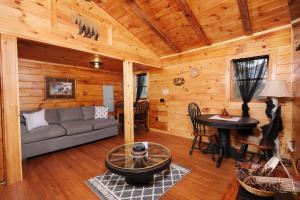 una sala de estar con sofá y mesa en una cabaña en Sleepy Bear, en Sevierville 30 fotos más